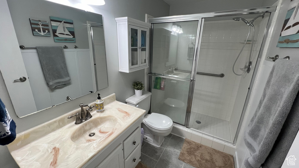 Full bath featuring vanity, a shower stall, and toilet