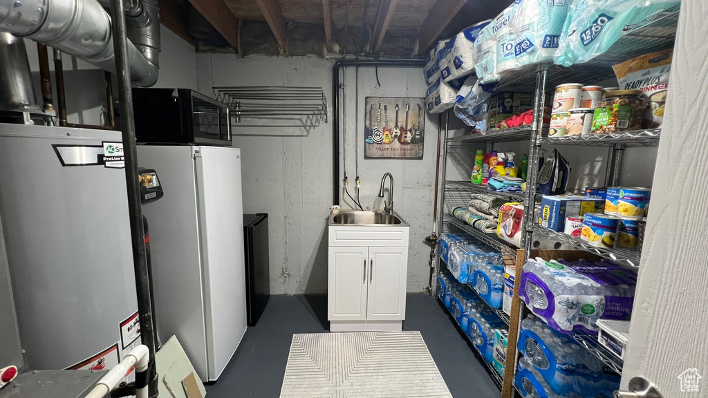 Below grade area featuring a sink and freestanding refrigerator