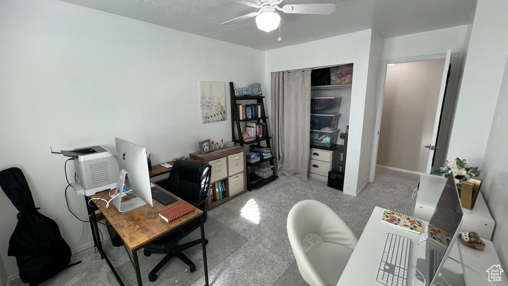 Carpeted office space with baseboards and a ceiling fan
