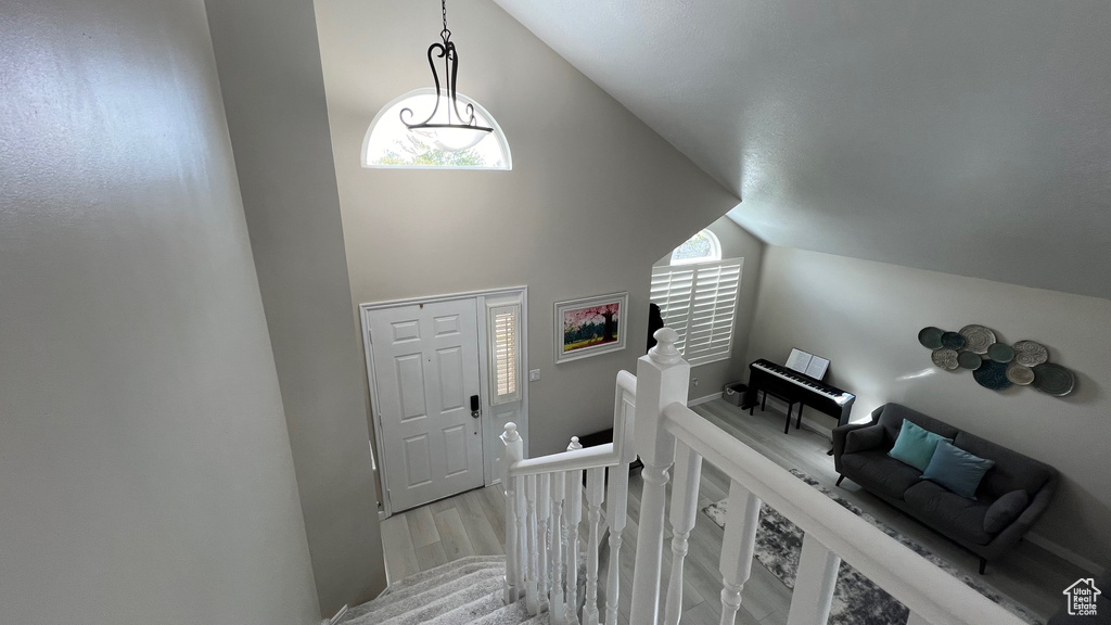 Entryway with high vaulted ceiling, a healthy amount of sunlight, and wood finished floors