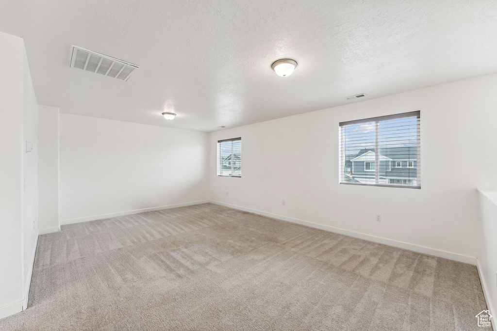 Spare room with baseboards, carpet flooring, and visible vents