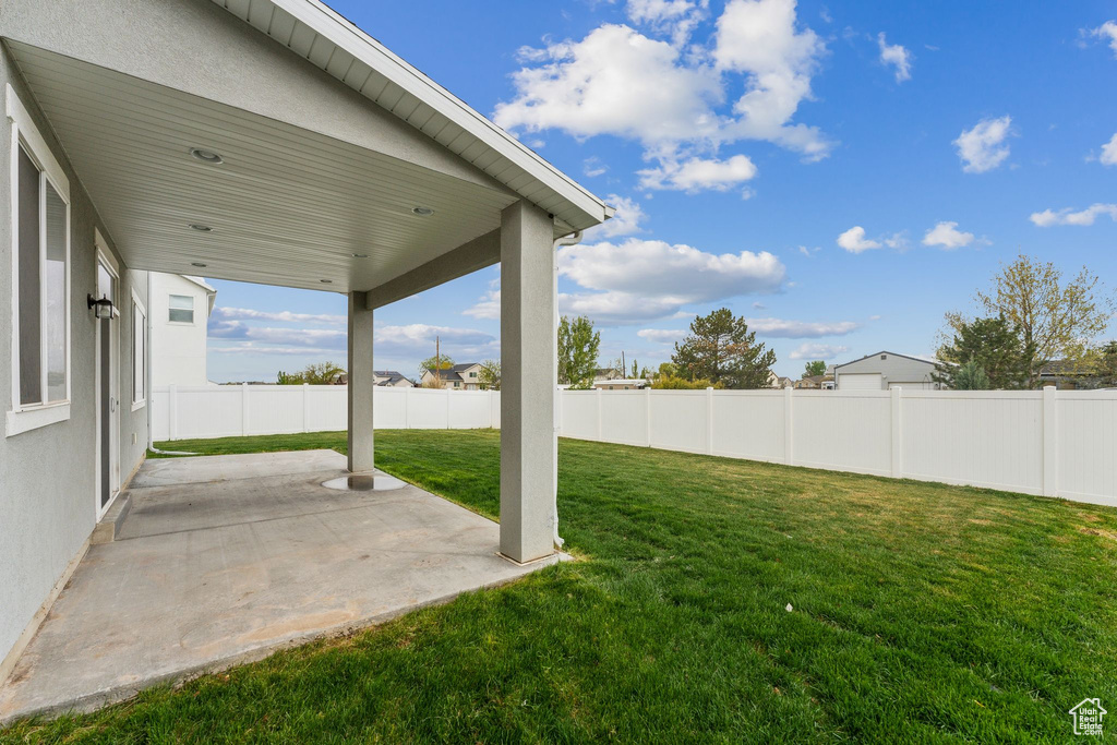 View of yard with fence and a patio area