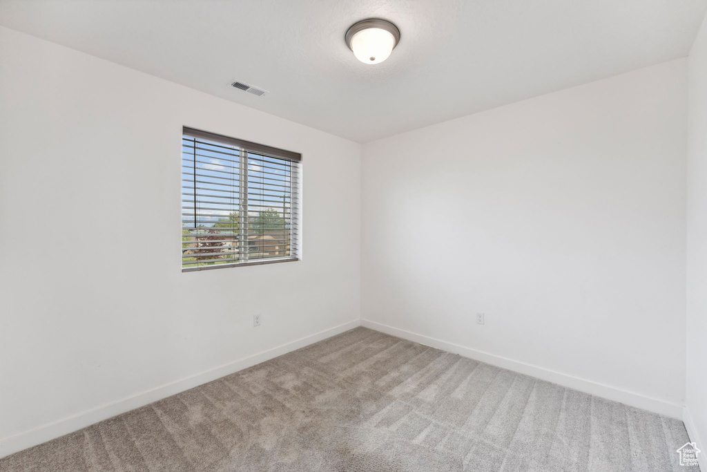 Unfurnished room with baseboards, visible vents, and carpet