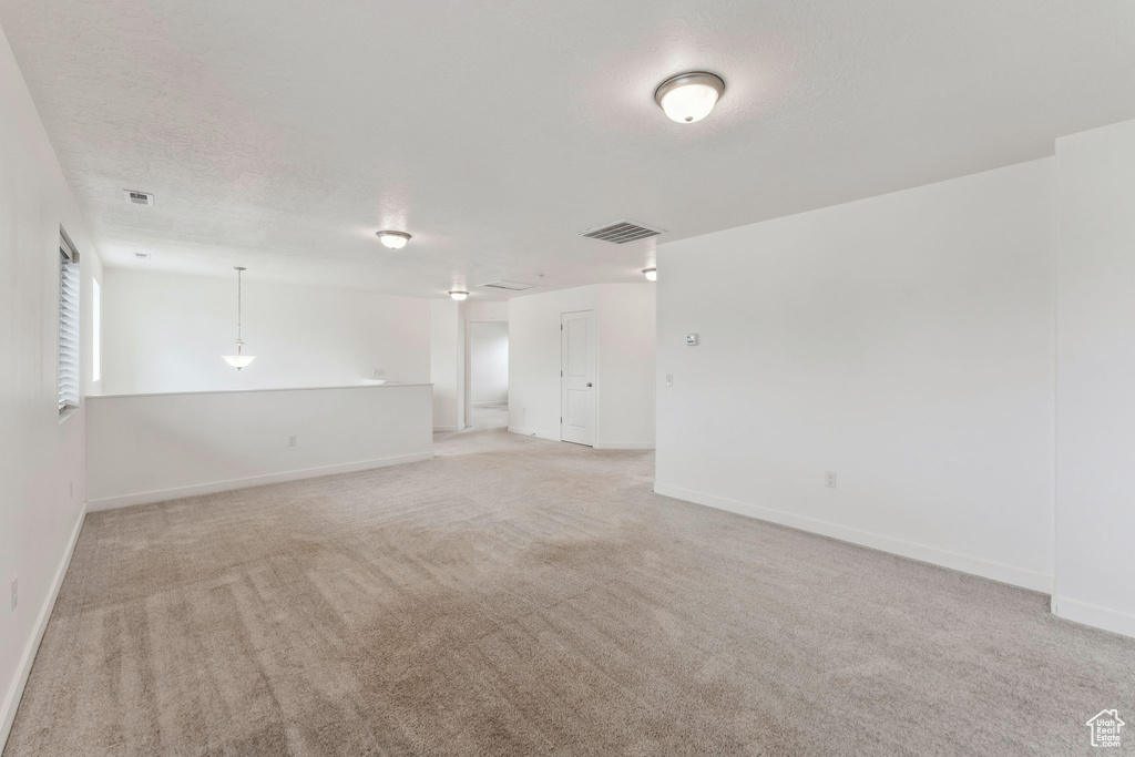 Unfurnished room featuring light colored carpet, baseboards, and visible vents
