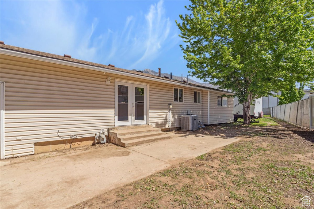 Back of house featuring french doors, central air condition unit, fence, a patio, and entry steps