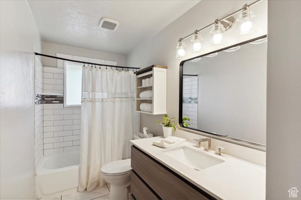 Full bath featuring vanity, toilet, visible vents, and shower / bath combo with shower curtain