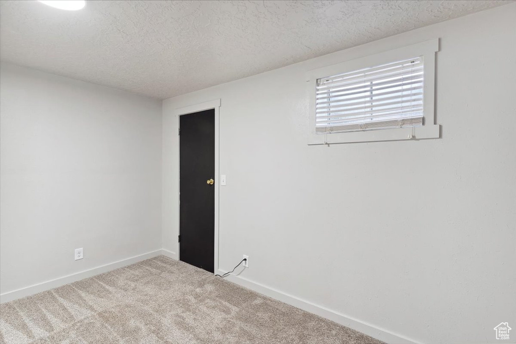 Unfurnished room with baseboards, carpet flooring, and a textured ceiling