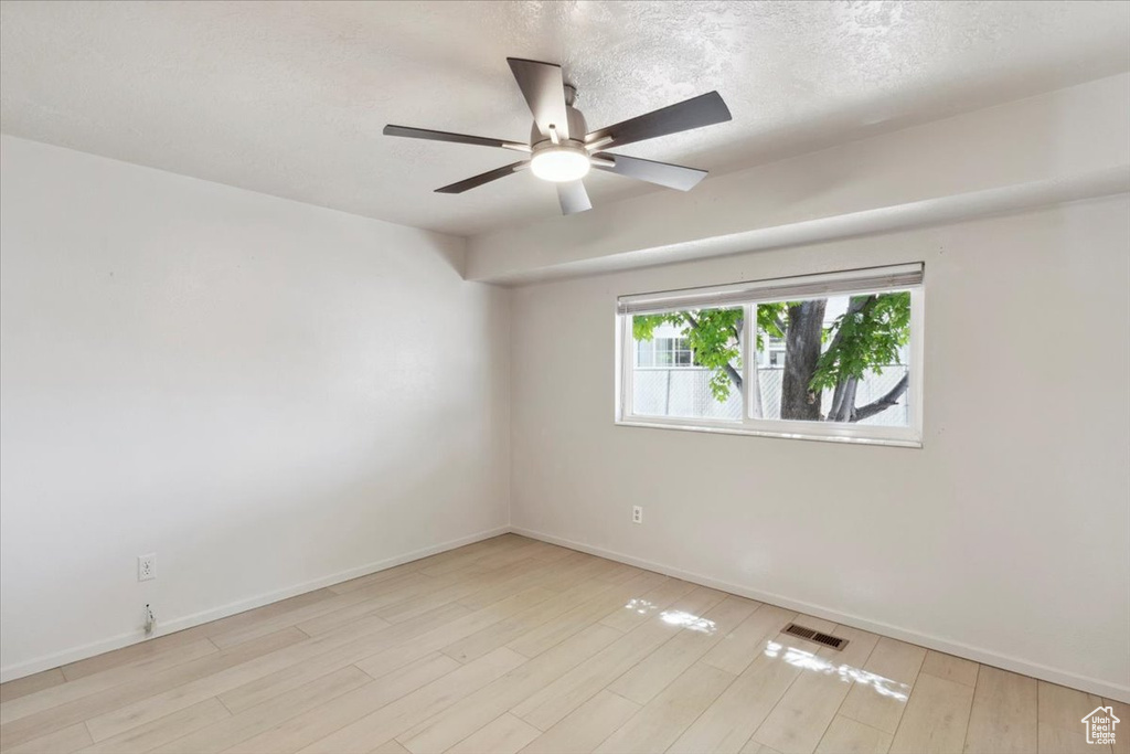 Unfurnished room featuring visible vents, baseboards, ceiling fan, and wood finished floors
