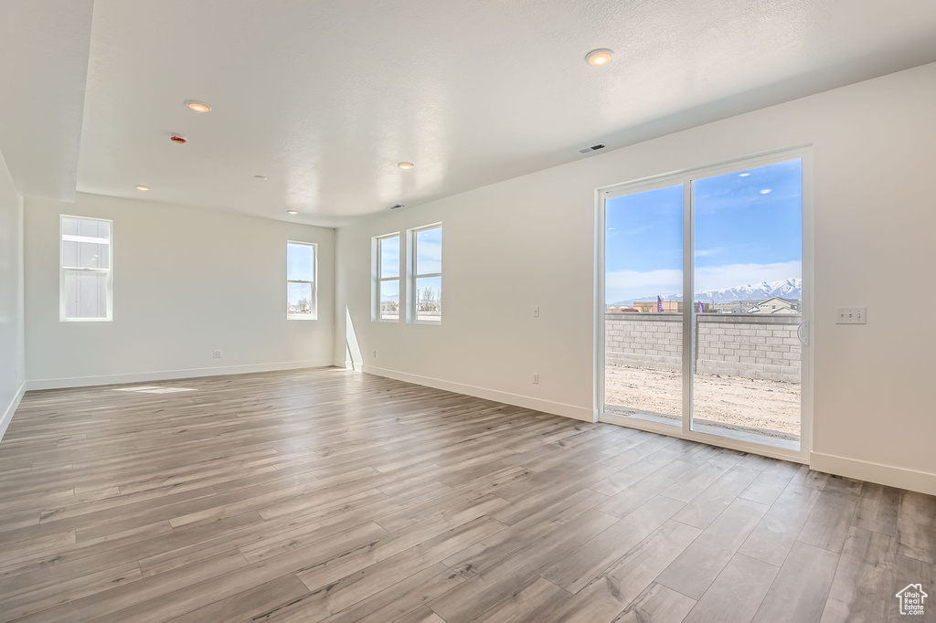 Unfurnished room featuring light wood finished floors, baseboards, and recessed lighting