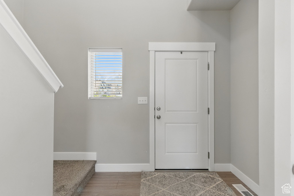 Entryway with visible vents, baseboards, and wood finished floors
