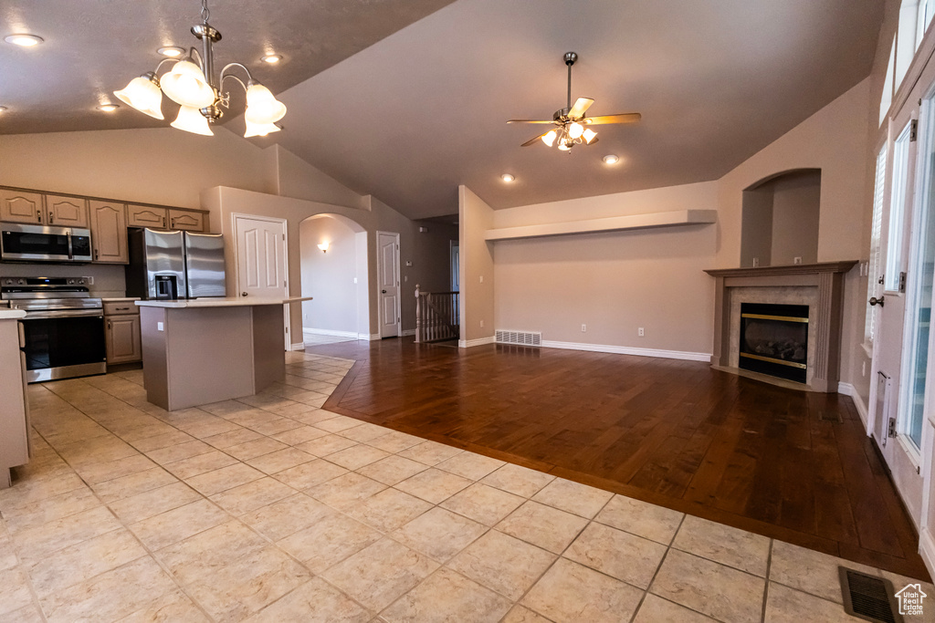 Kitchen featuring appliances with stainless steel finishes, light countertops, arched walkways, open floor plan, and visible vents