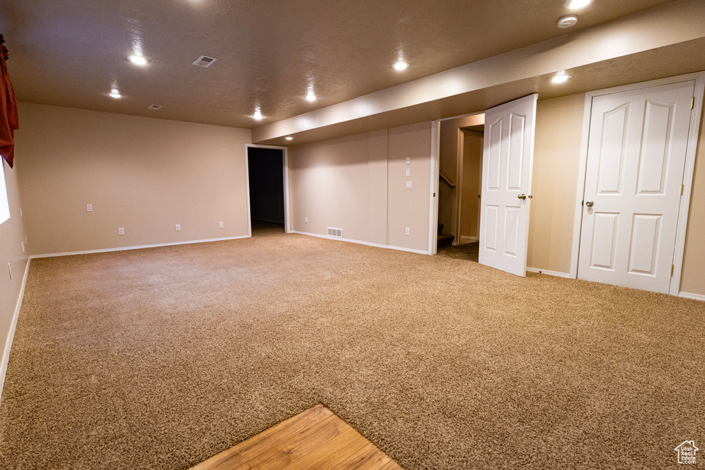 Spare room with baseboards, recessed lighting, and light colored carpet