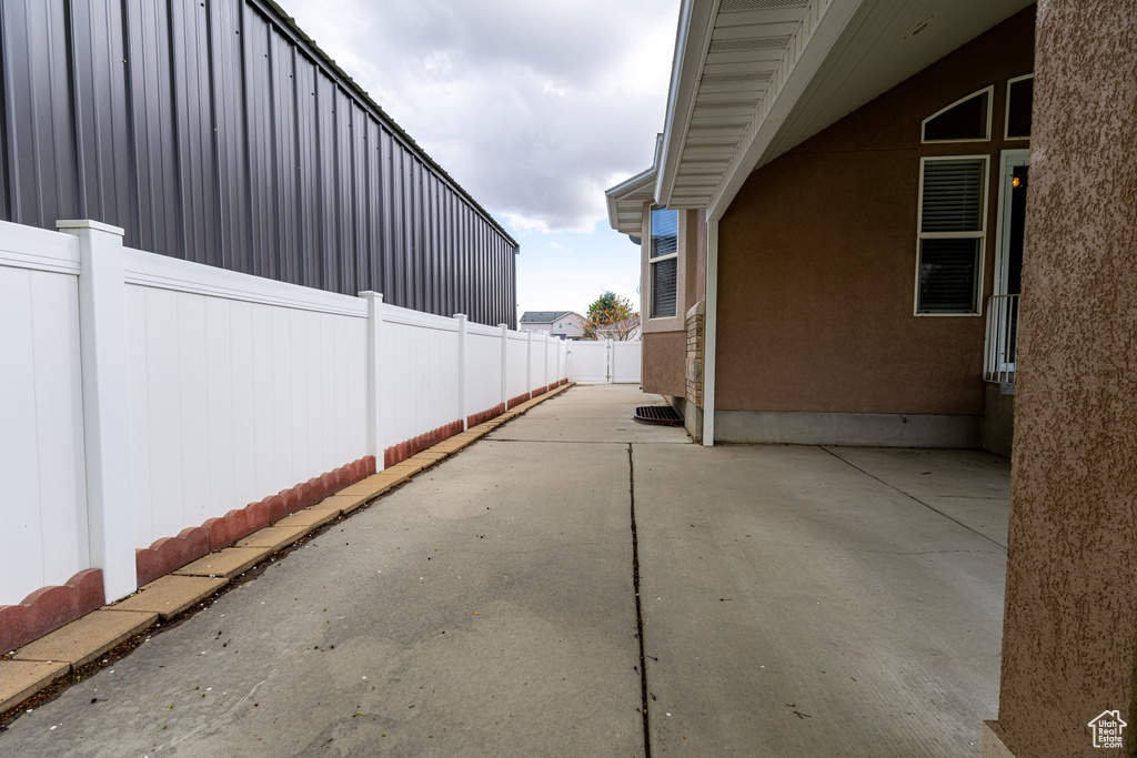 View of side of home with a fenced backyard, stucco siding, and a patio area