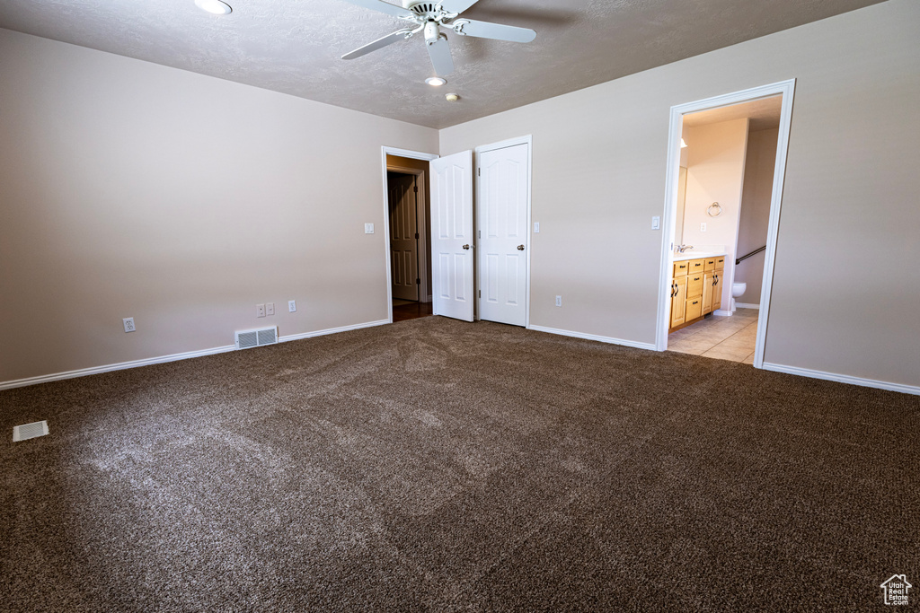 Unfurnished bedroom with visible vents, connected bathroom, baseboards, and light colored carpet