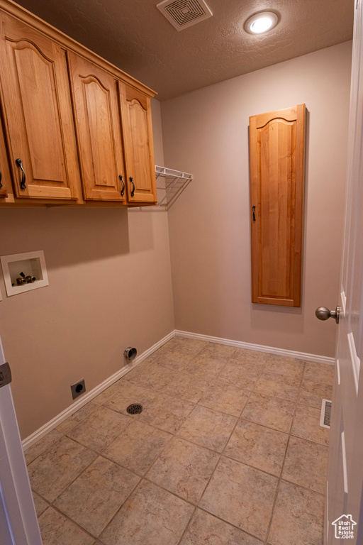 Laundry room featuring visible vents, a textured ceiling, cabinet space, washer hookup, and hookup for an electric dryer