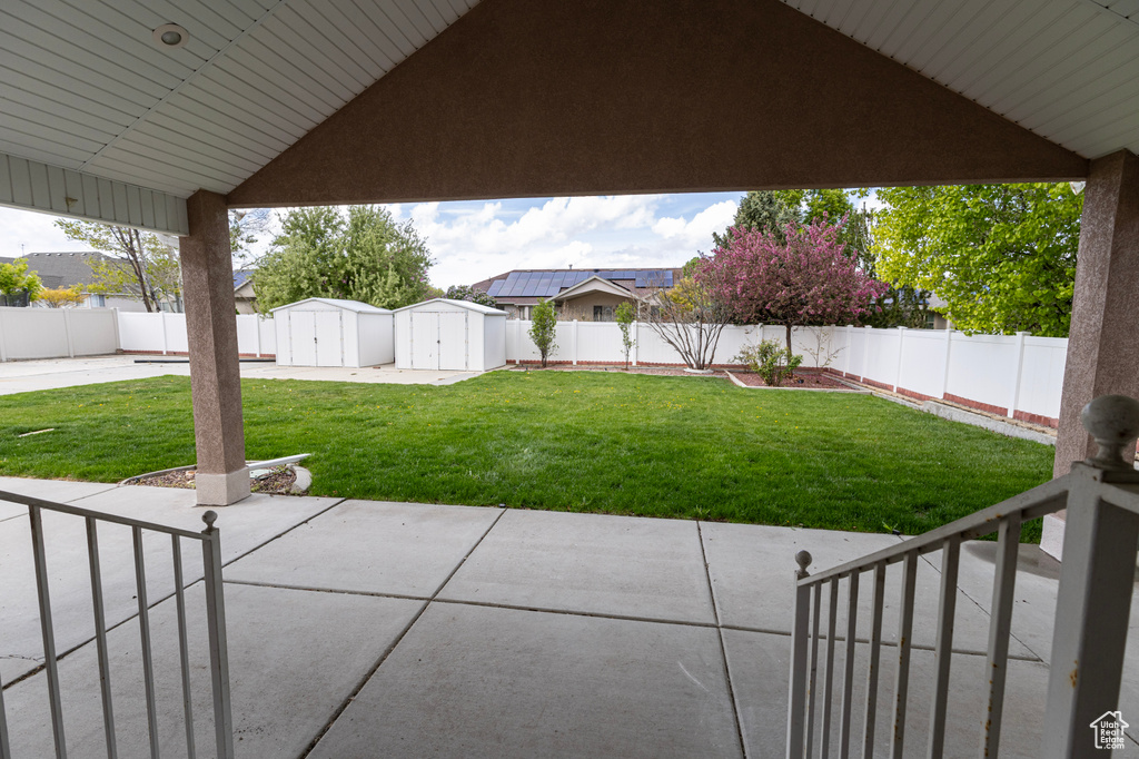 View of patio / terrace with an outdoor structure, a fenced backyard, and a storage unit