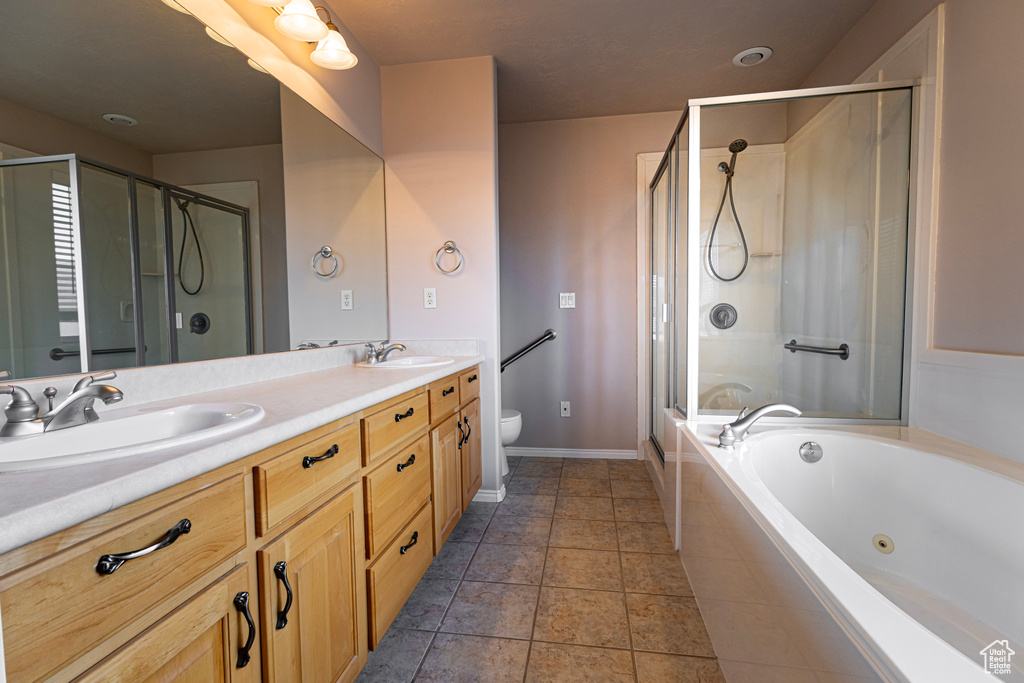 Full bathroom with double vanity, a tub with jets, a sink, and a stall shower