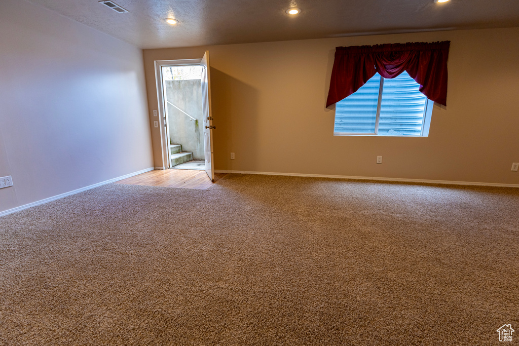 Unfurnished room featuring plenty of natural light, carpet flooring, recessed lighting, and visible vents