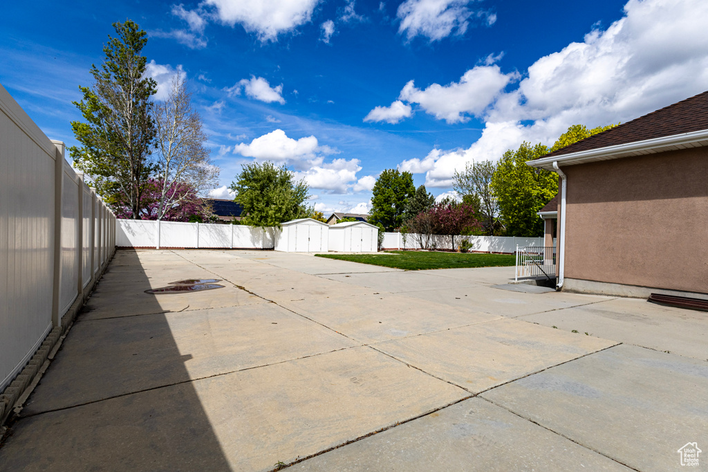 View of patio / terrace with an outbuilding, a shed, and a fenced backyard