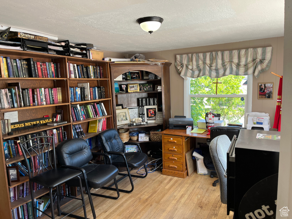 Home office featuring a textured ceiling and wood finished floors