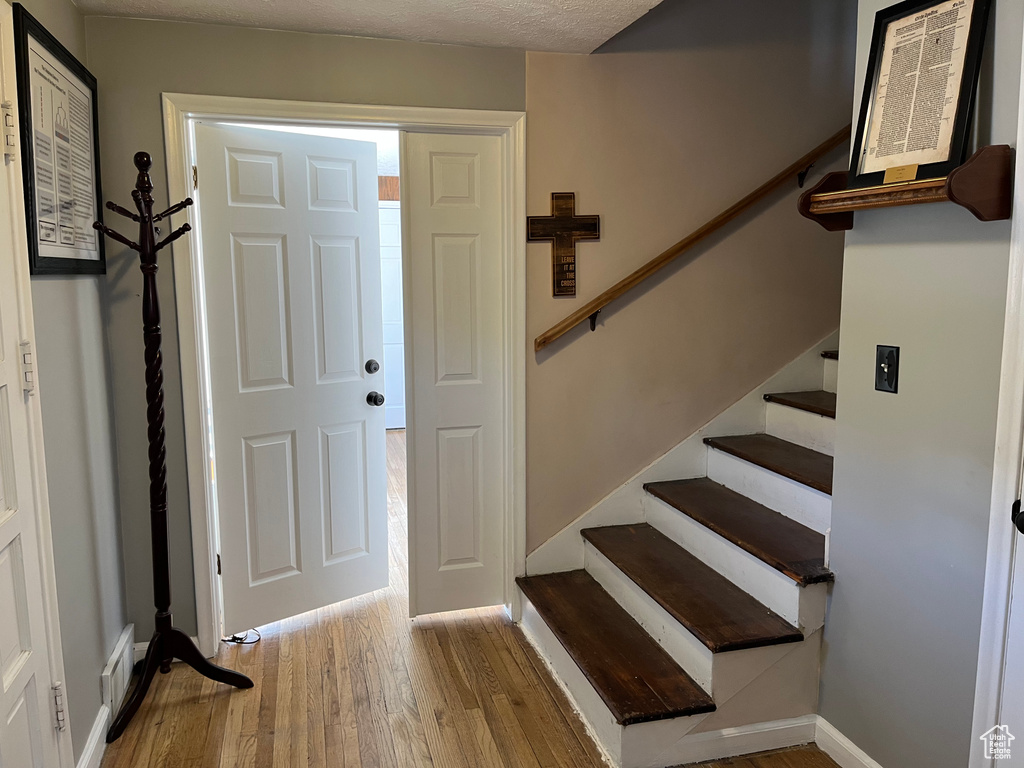 Foyer featuring baseboards, stairs, and wood finished floors