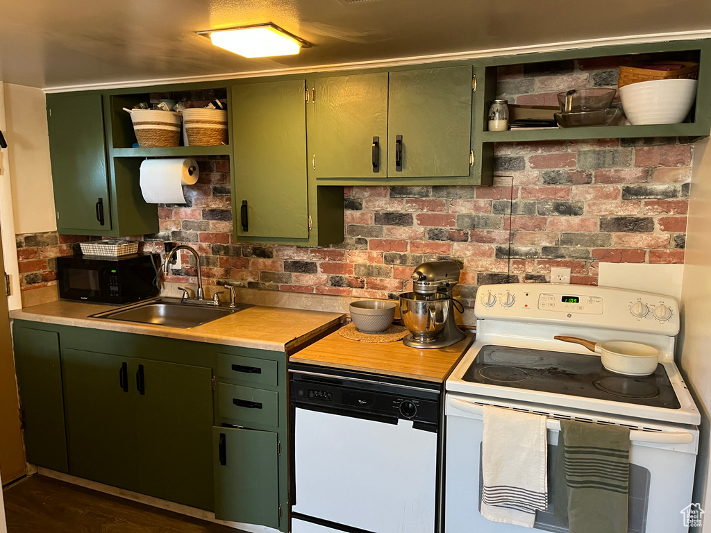 Kitchen featuring open shelves, a sink, white appliances, light countertops, and green cabinets