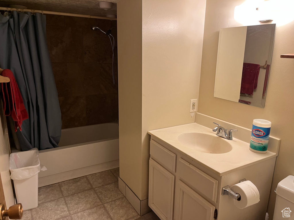 Bathroom featuring vanity, shower / bath combo with shower curtain, and toilet