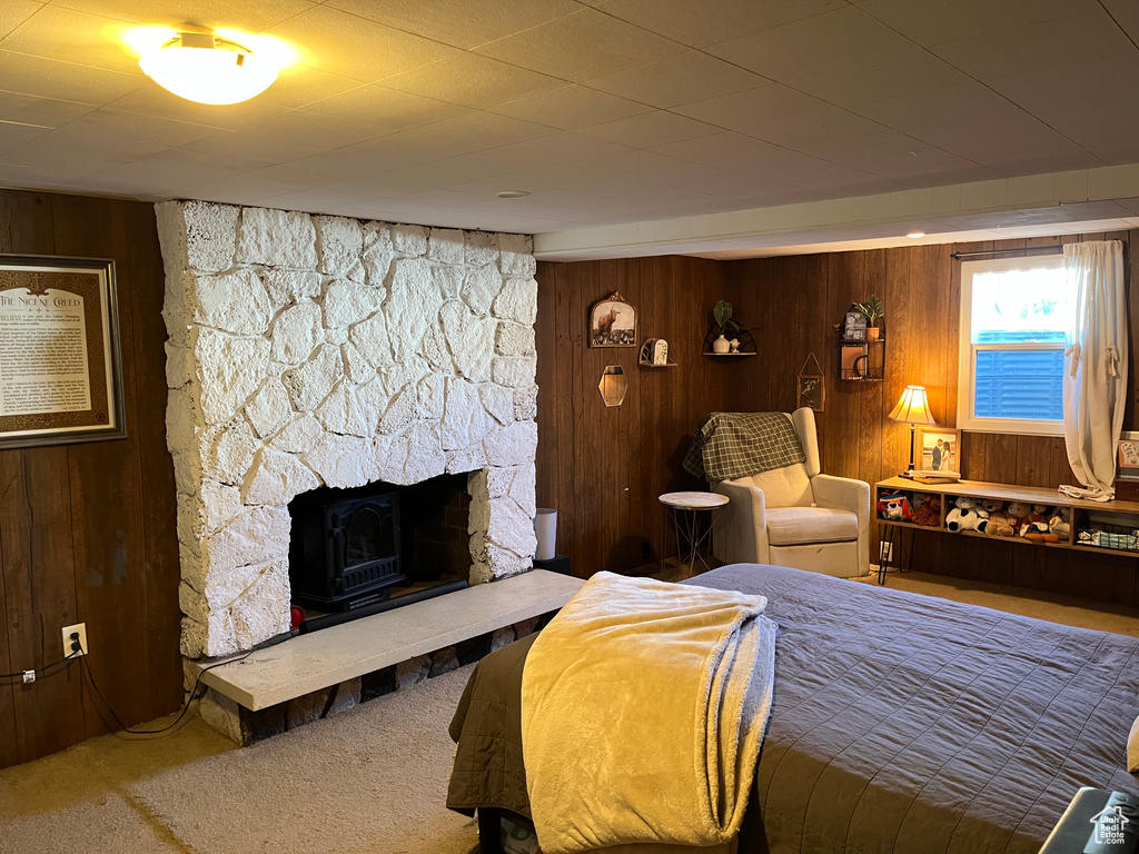 Carpeted bedroom featuring wood walls