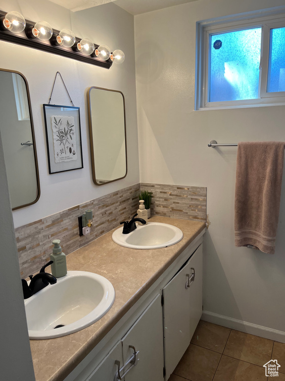 Full bath with tile patterned flooring, a sink, backsplash, and double vanity