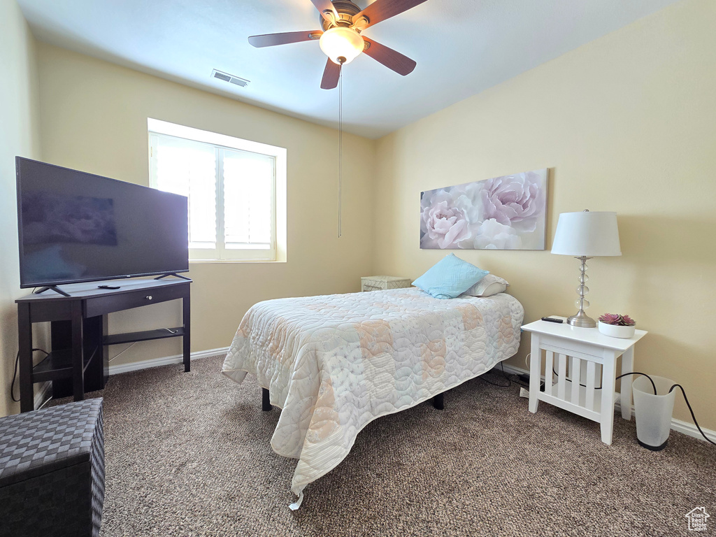 Carpeted bedroom featuring a ceiling fan, baseboards, and visible vents