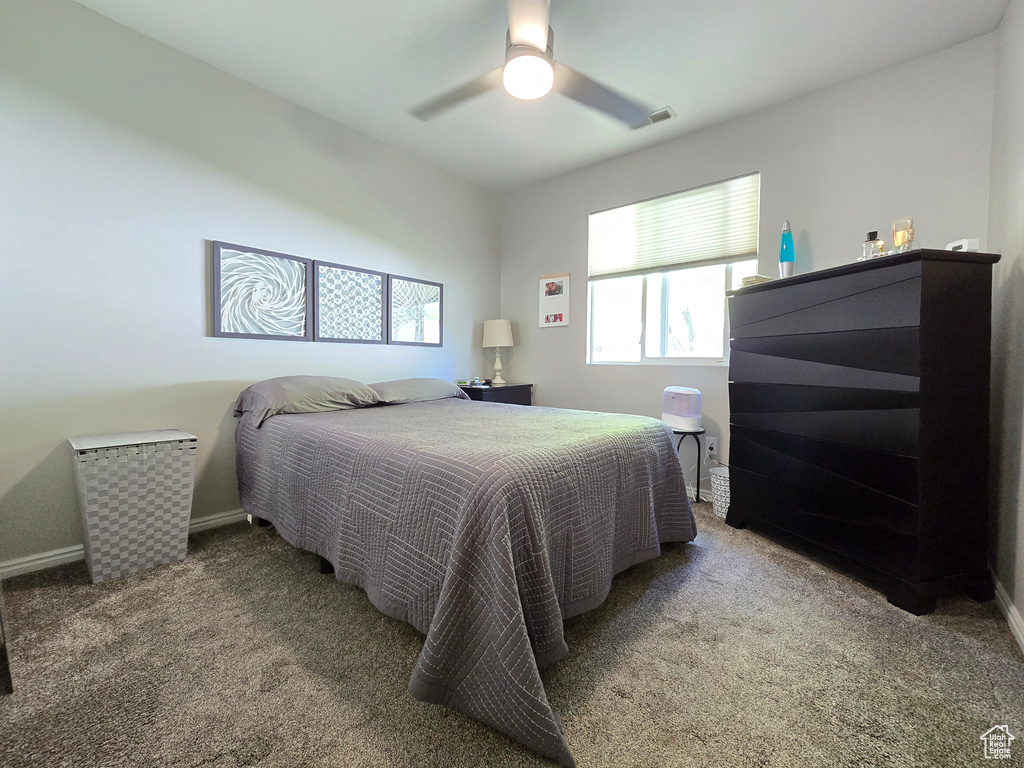 Bedroom featuring carpet floors, baseboards, visible vents, and ceiling fan