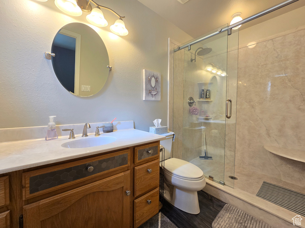 Full bathroom with vanity, a stall shower, and toilet