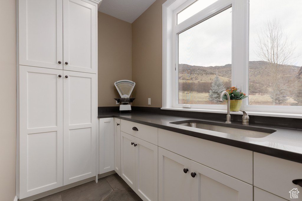 Kitchen with a mountain view, sink, and white cabinets