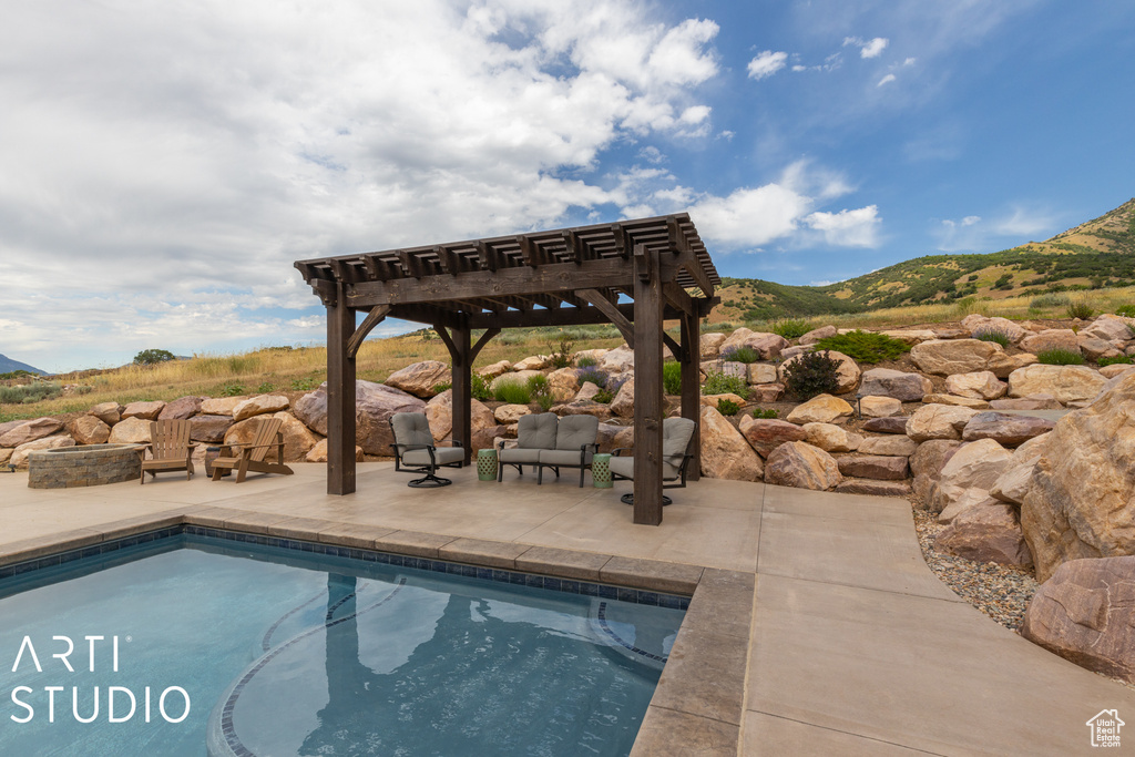 View of swimming pool with a mountain view, a patio area, and a pergola