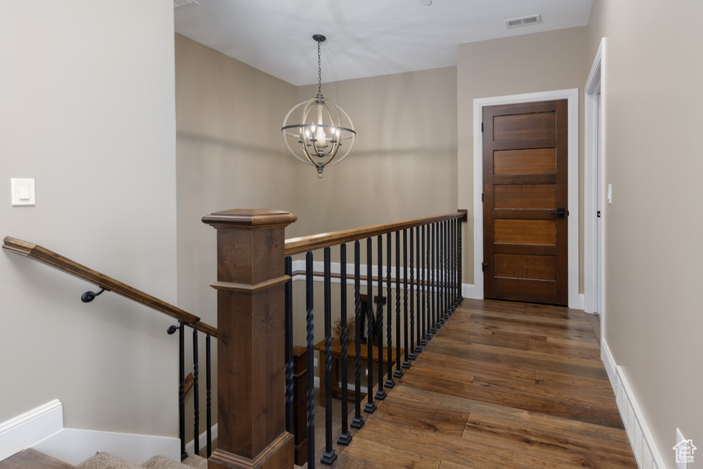 Stairway featuring a chandelier and hardwood / wood-style floors