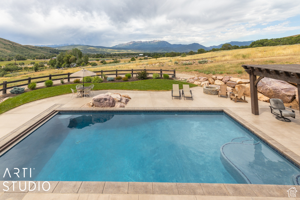 View of swimming pool with a patio, a mountain view, and a pergola