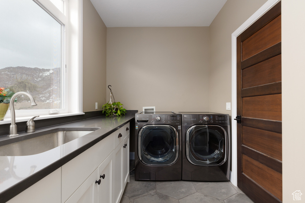 Washroom featuring sink, cabinets, light tile patterned floors, a mountain view, and washer and clothes dryer