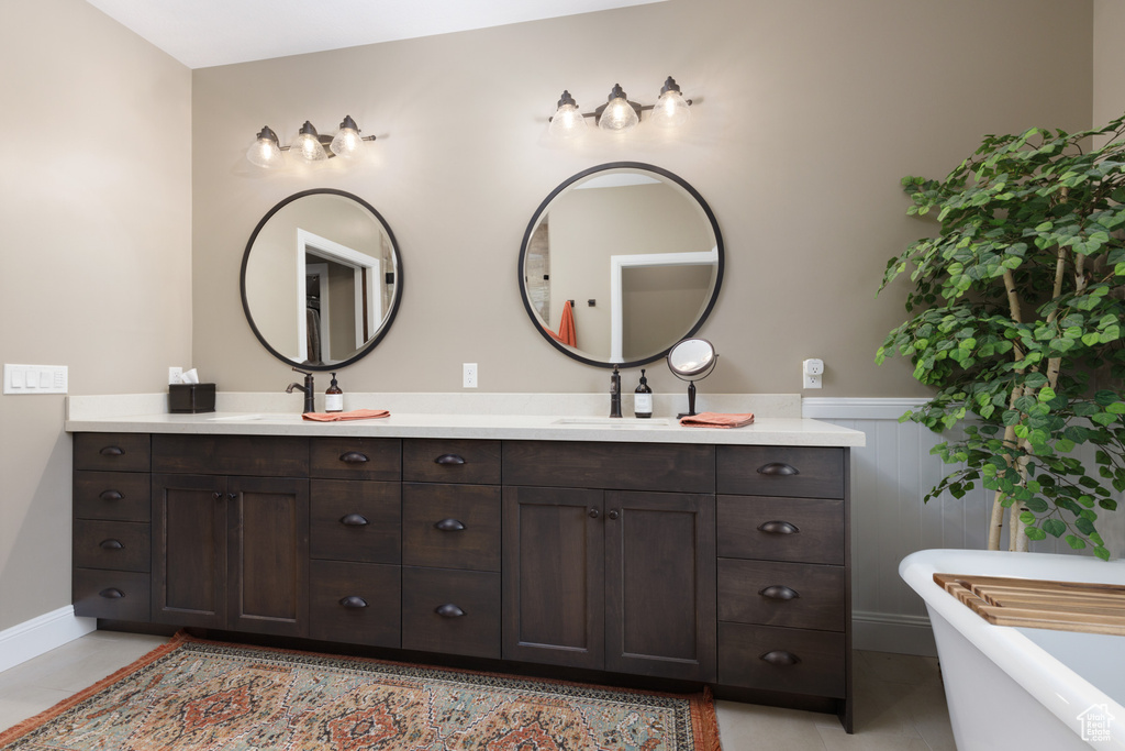Bathroom featuring vanity, tile patterned flooring, and a washtub
