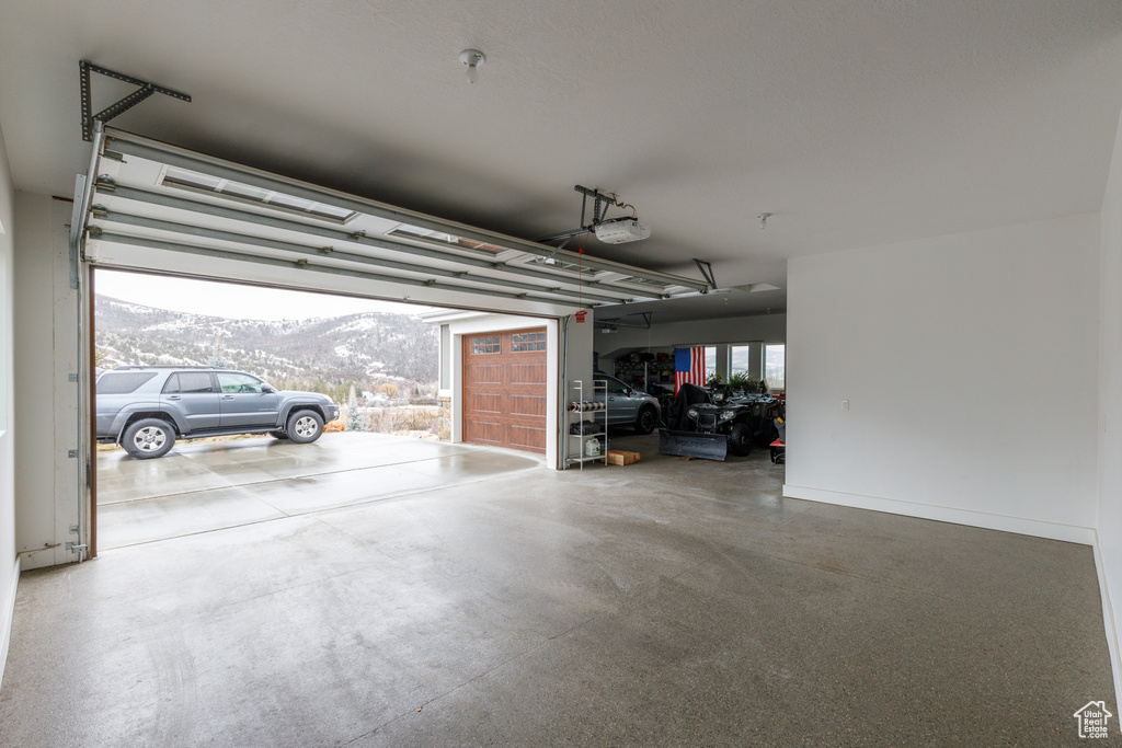 Garage featuring a carport, a mountain view, and a garage door opener