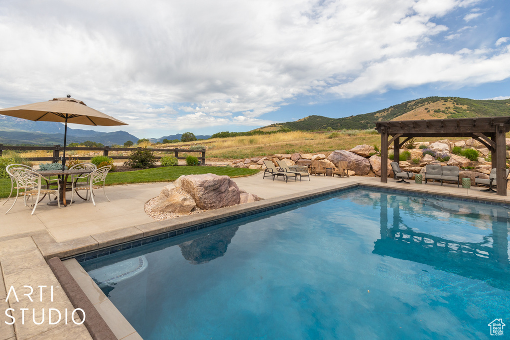 View of pool with a patio, a mountain view, and a pergola