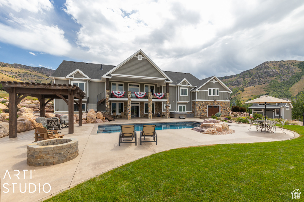 View of swimming pool featuring a patio, a lawn, an outdoor fire pit, a pergola, and a mountain view