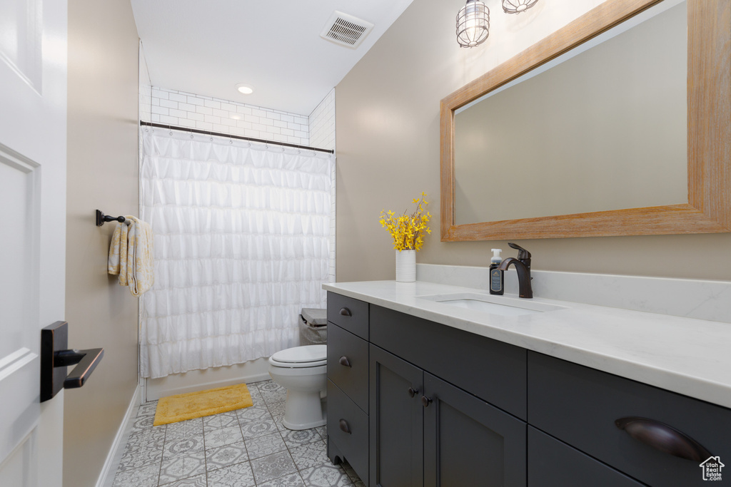 Full bathroom with shower / tub combo with curtain, vanity, toilet, and tile patterned flooring