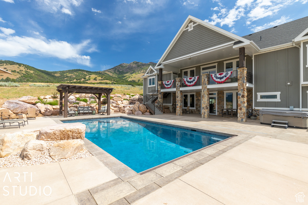 View of pool with a mountain view, a pergola, a hot tub, and a patio