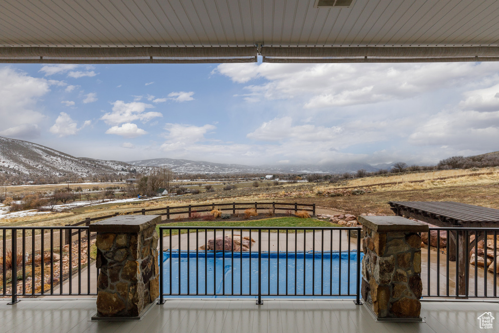 Deck with a fenced in pool and a mountain view