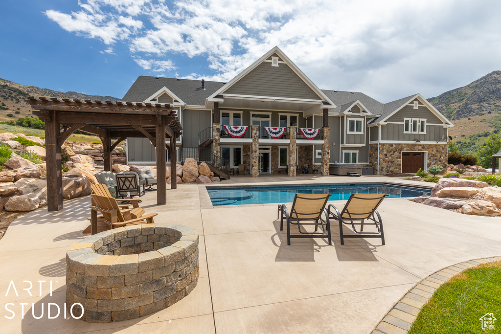 View of swimming pool with an outdoor fire pit, a pergola, a mountain view, and a patio area