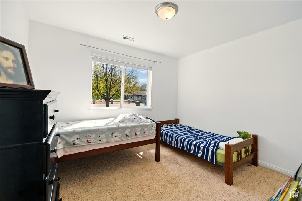 Bedroom featuring baseboards, carpet flooring, and visible vents