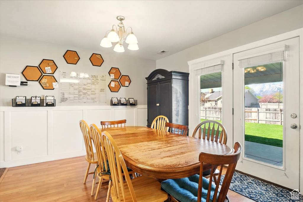 Dining area featuring visible vents, light wood finished floors, and a chandelier