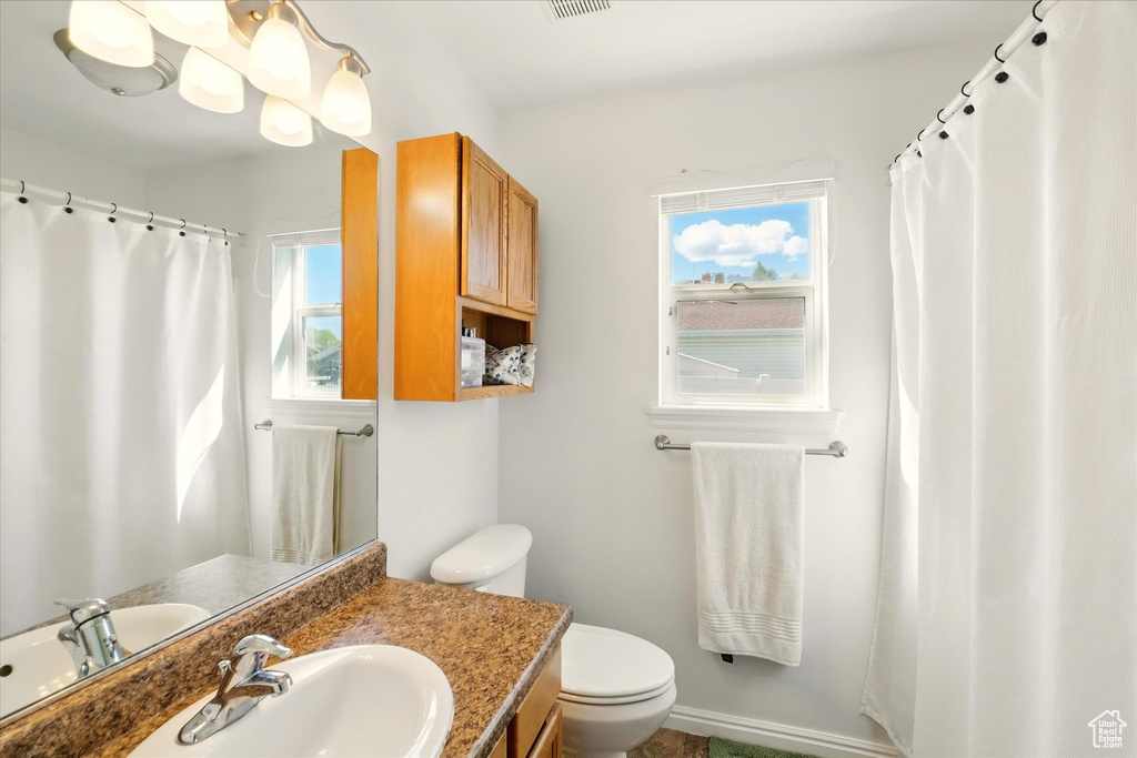 Bathroom with vanity, toilet, and visible vents