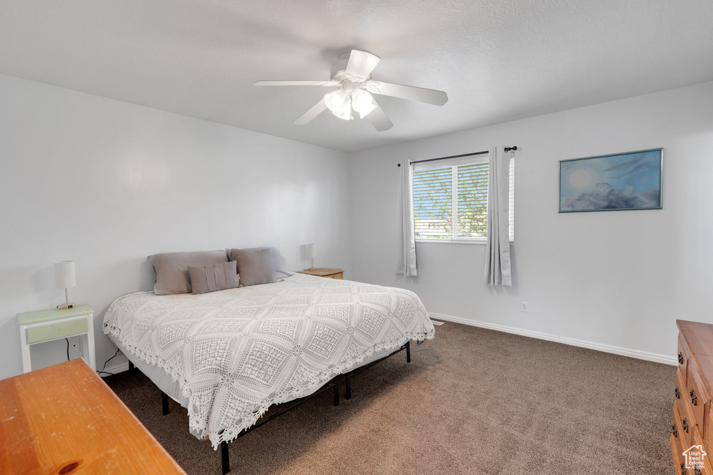 Bedroom with baseboards, a ceiling fan, and carpet