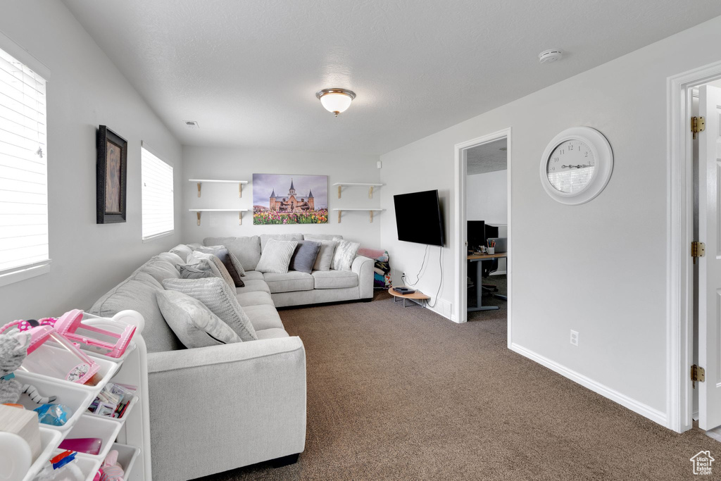 Carpeted living area featuring baseboards